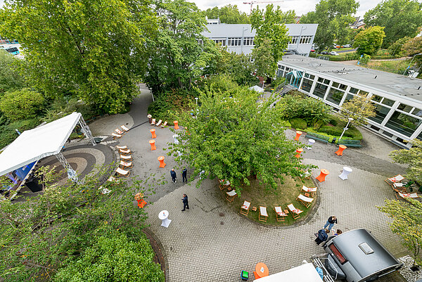Blick auf einen Garten mit Tischen.