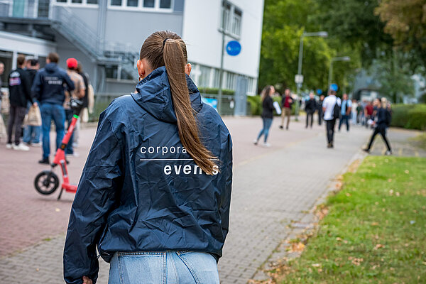 Person mit Jacke auf einem Gehweg