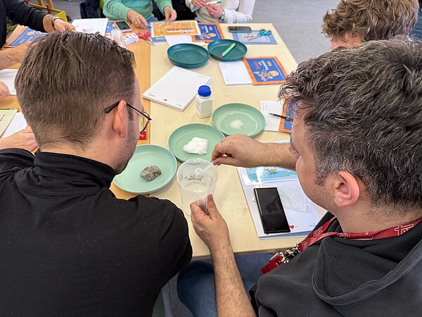 Teilnehmer führen ein Experiment mit Materialien durch. Zwei Personen bei einem Experiment.