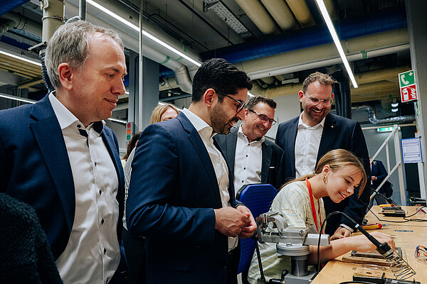 Dr. Frank Martin, Kaweh Mansoori, Torsten Rauch und Alexander Hupert, Teilnehmerin von Girls4MINT Gruppendiskussion in einer Werkstatt